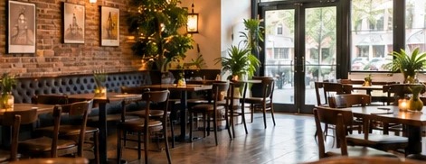 An empty restaurant dining room with booths and brick walls, ready for an event.
